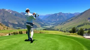 Golfer mid-swing on elevated tee box with mountain landscape and valley below, clear blue sky, professional posture and form
